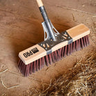 Industrial street broom designed for sweeping heavy debris on extra-rough surfaces.